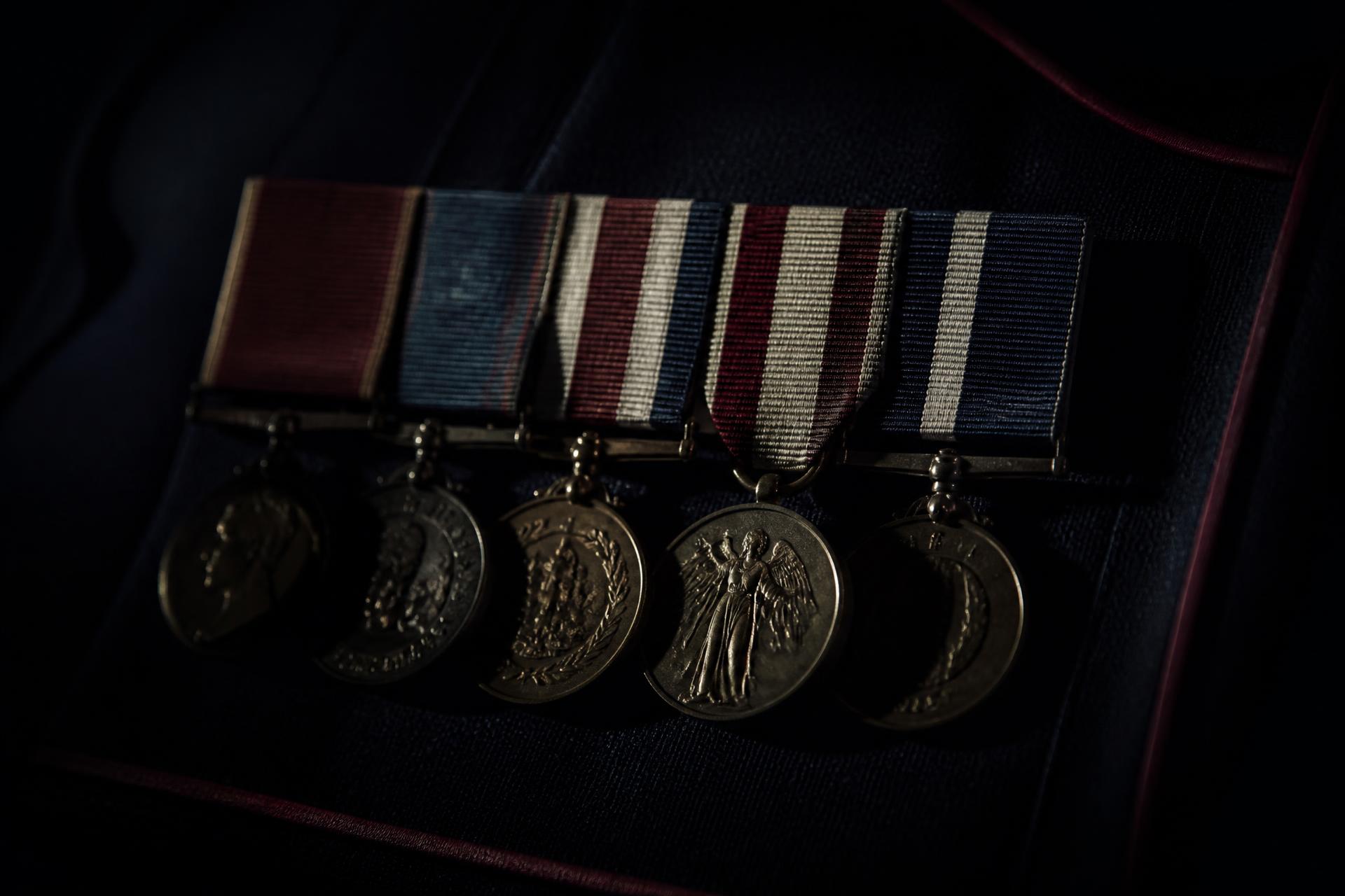 Detail of British service medals and medal ribbons resting on dark ceremonial dress fabric